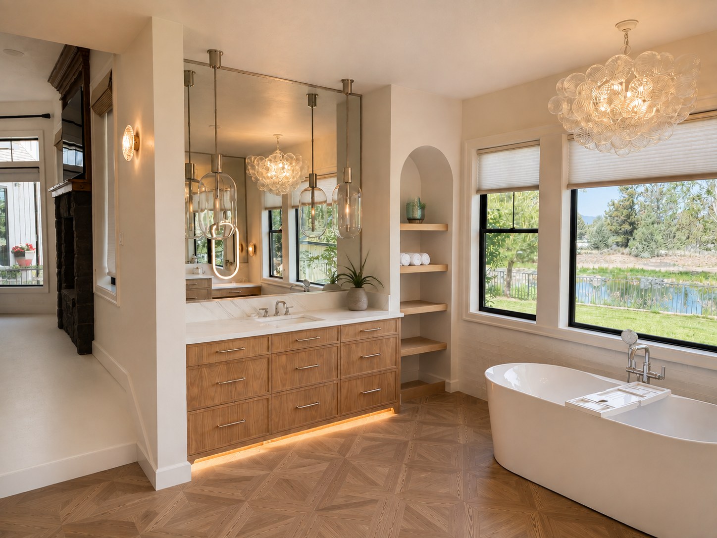 Master bath remodel with herringbone parquet floor, bubble glass chandelier, walnut vanity, freestanding soaking tub, and pond views — Voorhies Residence, Bend Oregon