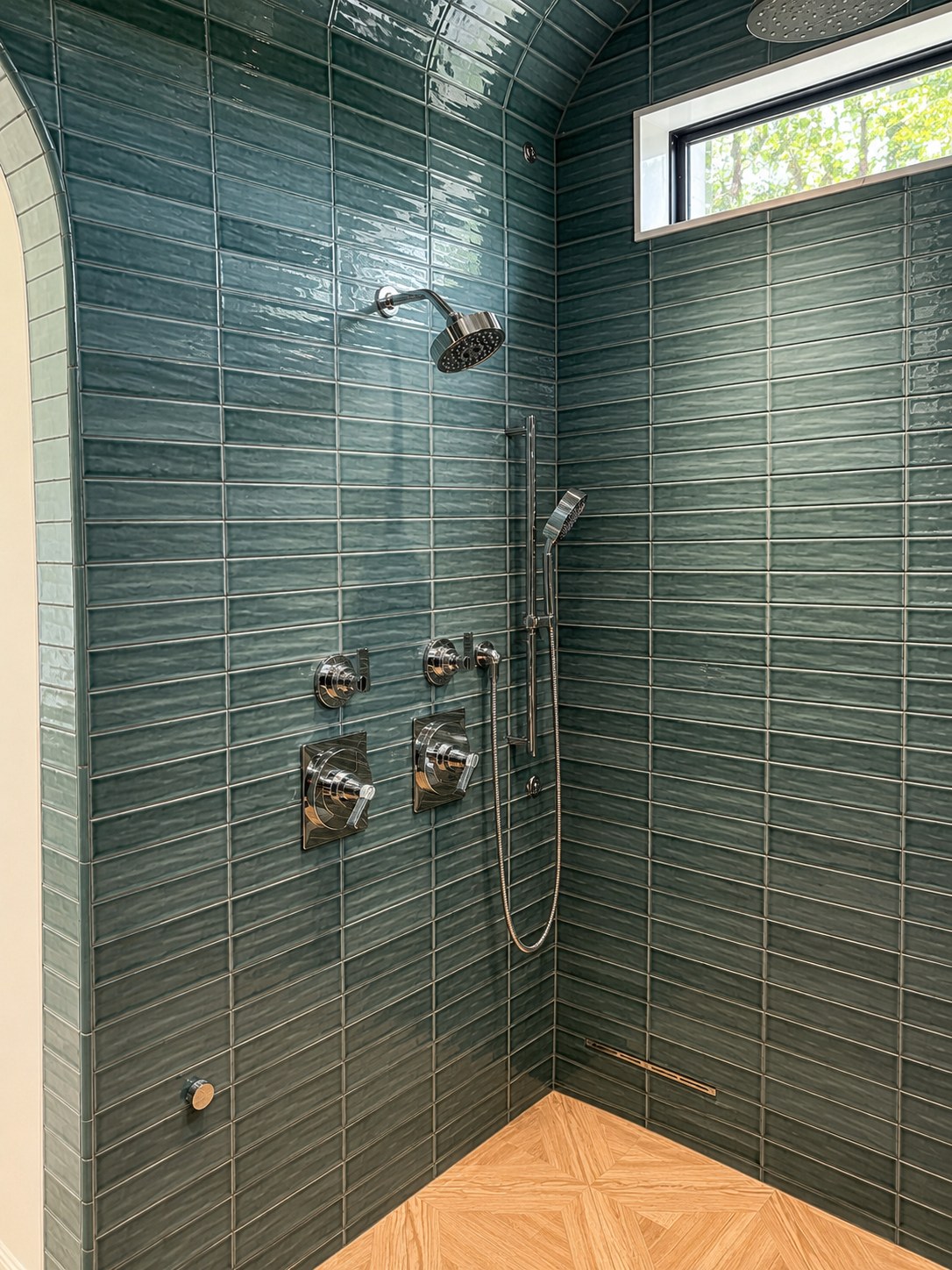 Master steam shower with arched marble entry, floor-to-ceiling forest green glazed tile, teak parquet floor, and ceiling rainfall head — Voorhies Residence, Bend Oregon