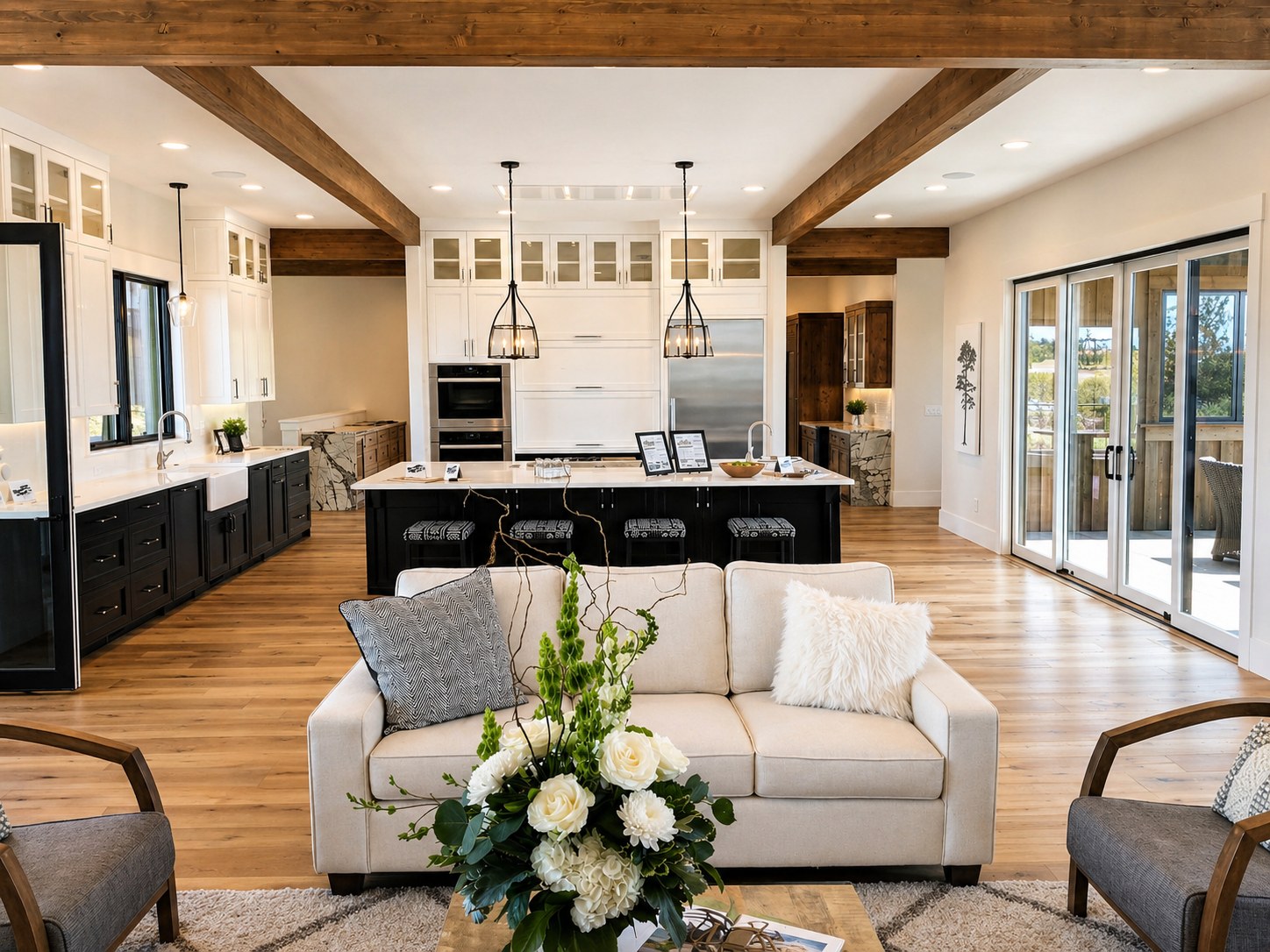 Brasada Ranch custom home kitchen — white perimeter cabinets, black island, exposed wood beam ceiling, farmhouse sink, pendant lights — LT Northwest Builders